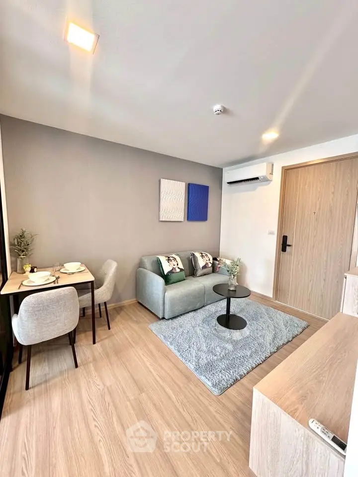 Modern living room with cozy seating and dining area, featuring stylish decor and wooden flooring.