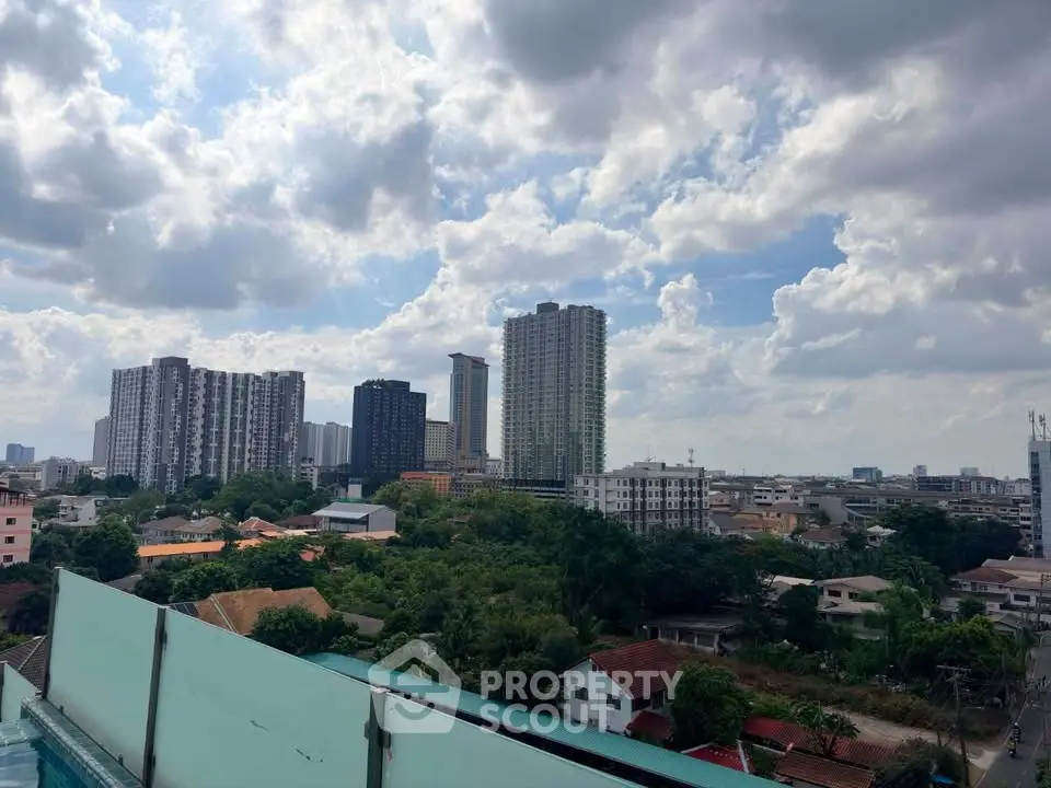 Stunning cityscape view from a rooftop with lush greenery and modern high-rise buildings.