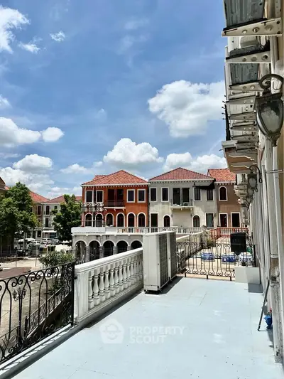 Charming balcony view of Mediterranean-style homes under a bright blue sky.