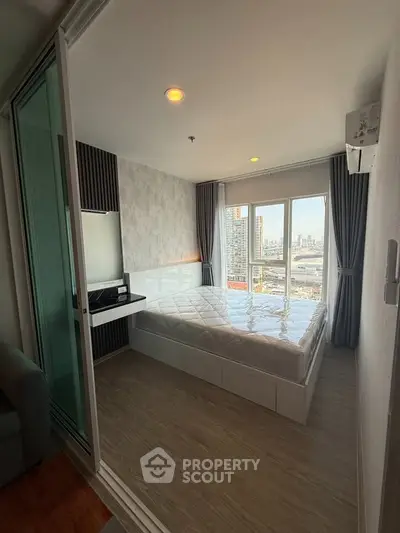 Modern bedroom with city view, featuring large windows and stylish decor in a high-rise apartment.