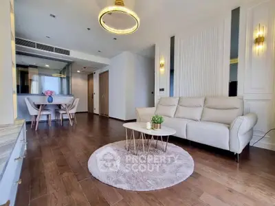 Luxurious modern living room with elegant decor and open dining area, featuring stylish lighting and hardwood floors.