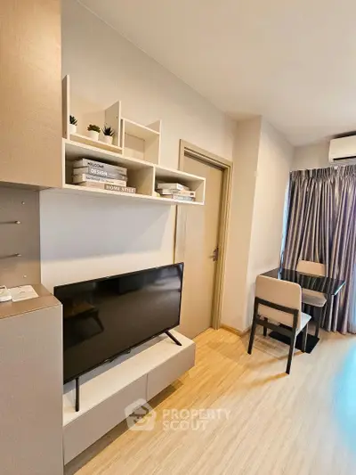 Modern living room with sleek TV setup and stylish dining area, perfect for urban living.