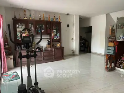 Spacious living room with exercise equipment and trophy display, ideal for active lifestyle.