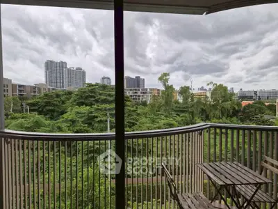 Spacious balcony with lush green views and city skyline, perfect for relaxation.