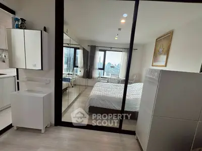 Modern bedroom with city view, mirrored closet, and sleek furnishings