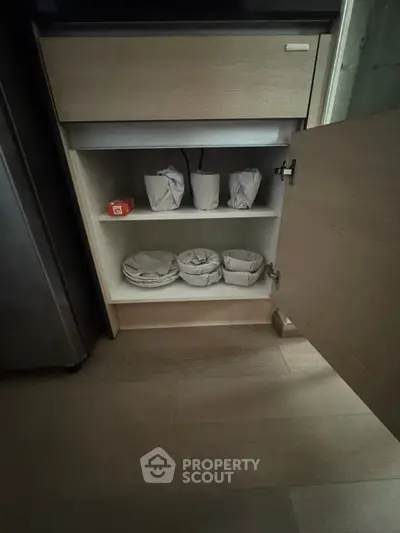 Modern kitchen cabinet with open door revealing organized storage space.