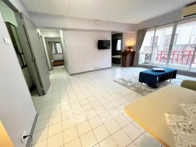 Spacious living room with large windows and balcony access in modern apartment.