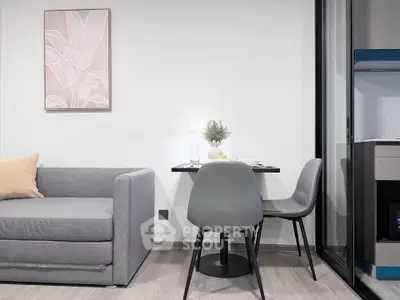 Modern living room with stylish gray sofa and compact dining area, perfect for urban living.