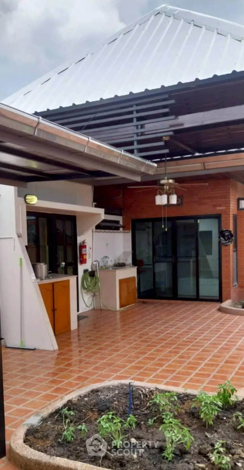Charming outdoor patio with modern roof and brick accents, perfect for entertaining.