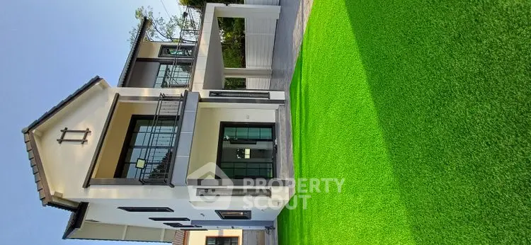 Stunning modern house with lush green lawn and elegant architecture.