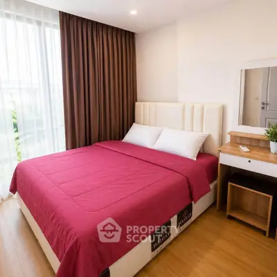 Modern bedroom with red bedding, large window, and stylish furniture