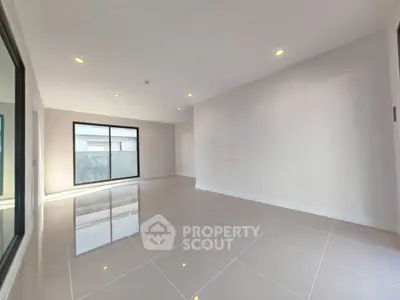 Spacious modern living room with glossy tiled floors and large windows.