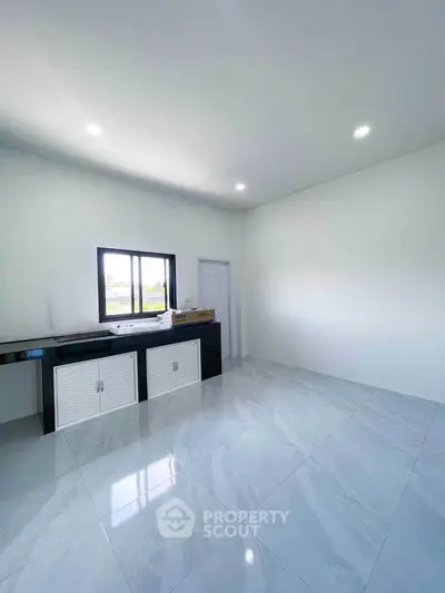 Spacious minimalist room with sleek flooring and modern cabinetry