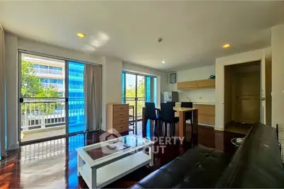 Spacious living room with modern furniture and large windows offering natural light and a view.