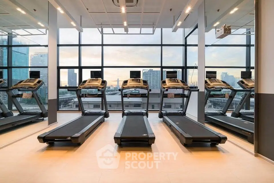 Modern gym with treadmills and city view through large windows