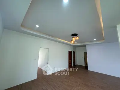 Spacious modern living room with stylish ceiling lights and wooden flooring