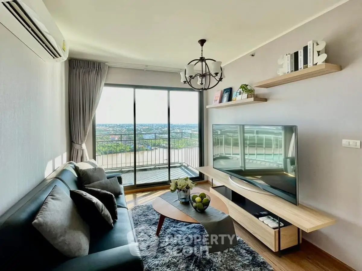 Modern living room with balcony and stunning view, featuring stylish decor and large TV.