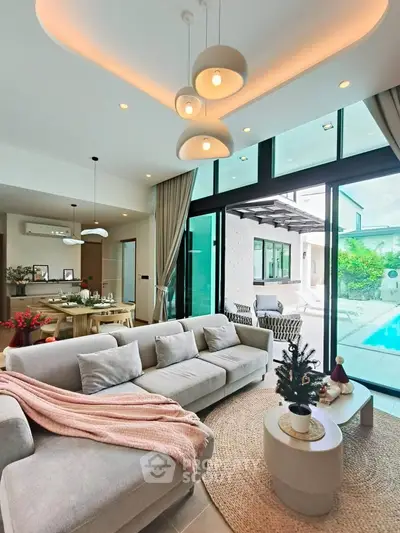 Luxurious living room with pool view, modern decor, and elegant lighting in a contemporary home.