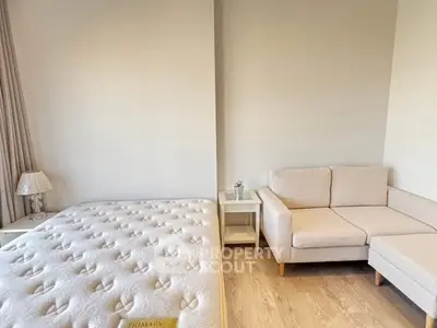 Spacious bedroom with cozy seating area and modern decor