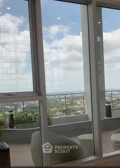 Stunning view from a modern apartment balcony with glass doors and outdoor seating.