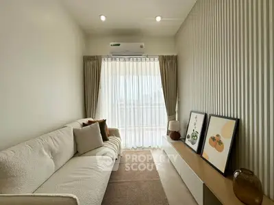 Cozy living room with modern decor and large window for natural light.