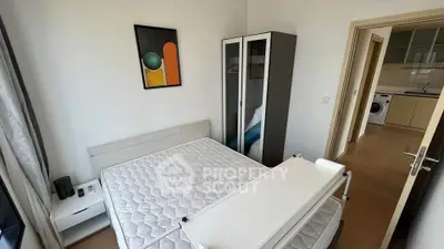 Modern bedroom with minimalist decor and adjacent kitchen view