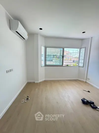 Spacious unfurnished room with large windows and air conditioning, perfect for customization.