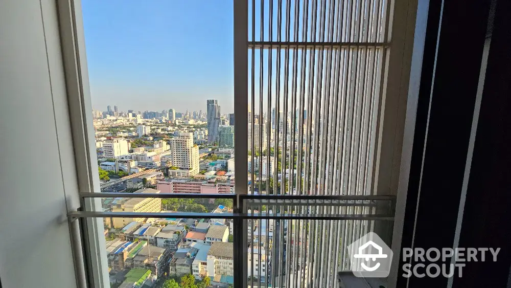 Stunning cityscape view from high-rise apartment window with modern railing.