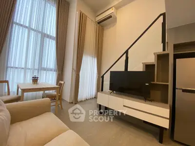 Modern living room with high ceilings, large windows, and stylish furniture in a contemporary apartment.