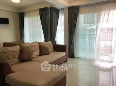 Spacious living room with elegant curtains and comfortable sofa in modern apartment.