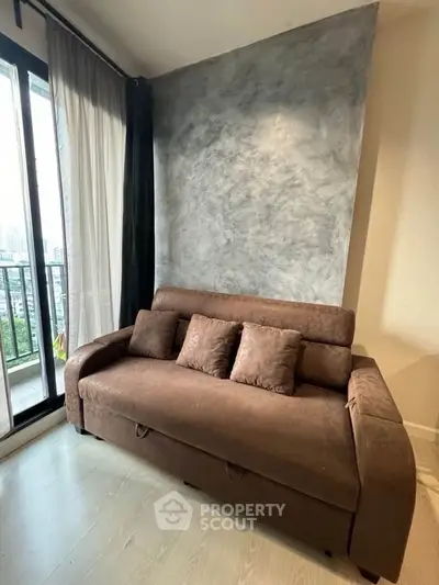 Modern living room with stylish sofa and large window offering city view