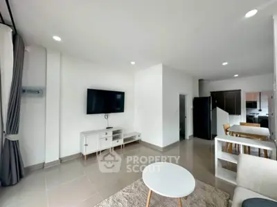 Modern living room with sleek TV setup and open kitchen layout