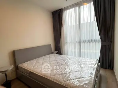 Modern bedroom with large window and elegant curtains in a cozy apartment.