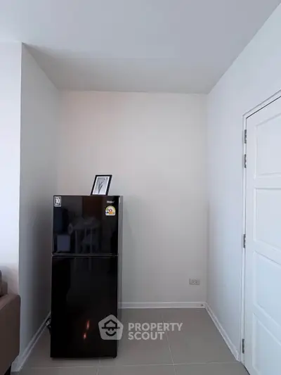 Modern kitchen corner with sleek black fridge and minimalist decor