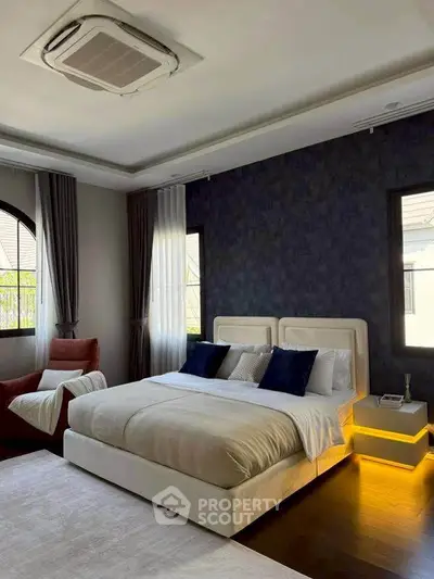 Luxurious bedroom with modern decor and ambient lighting, featuring a cozy bed and stylish armchair.