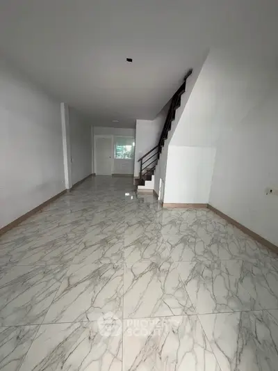 Spacious modern living room with elegant marble flooring and stylish staircase, perfect for contemporary living.