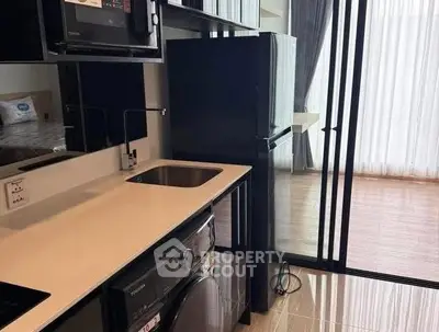 Modern kitchen with sleek appliances and open layout in stylish apartment.