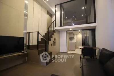 Modern duplex living room with sleek staircase and open kitchen layout