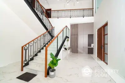 Elegant modern entrance with marble flooring and stylish staircase