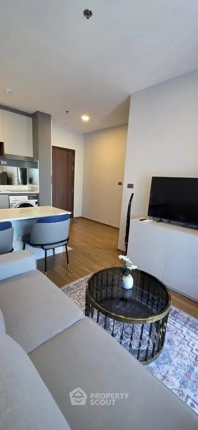 Modern living room with stylish furniture and open kitchen layout in a contemporary apartment.