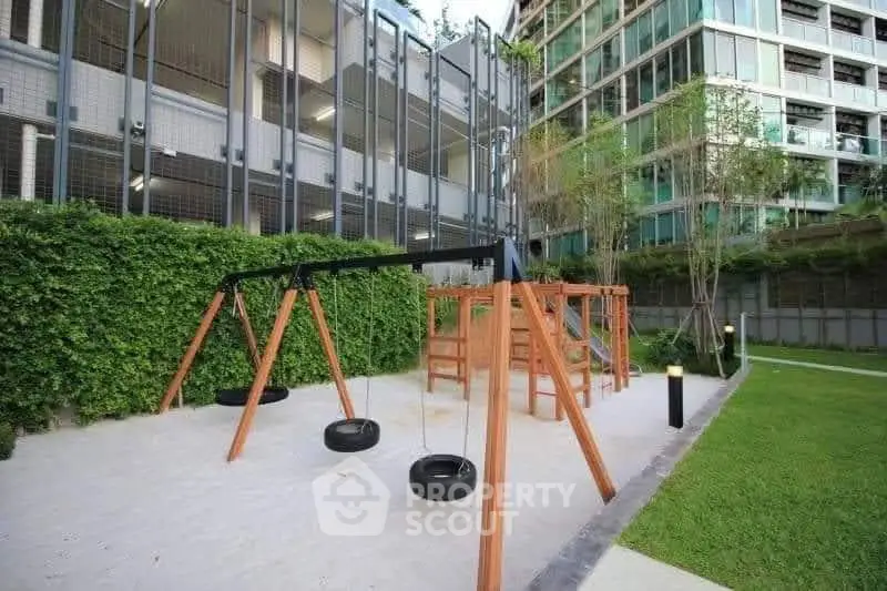 Modern apartment complex with playground and lush greenery