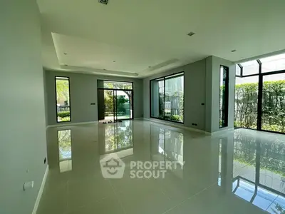 Spacious modern living room with large windows and glossy tile flooring