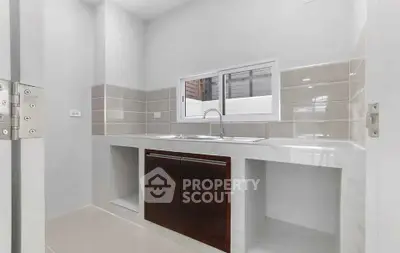 Modern kitchen with sleek countertops and dual sinks, featuring a minimalist design and neutral tones.