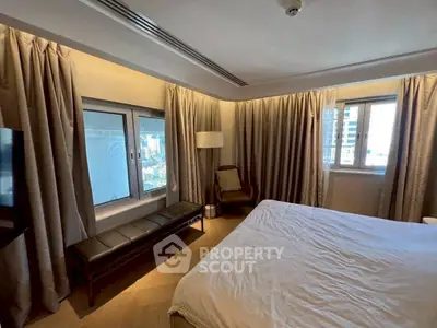 Spacious bedroom with city view, modern furnishings, and ample natural light.