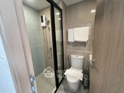 Modern bathroom with glass shower and sleek fixtures in contemporary apartment.