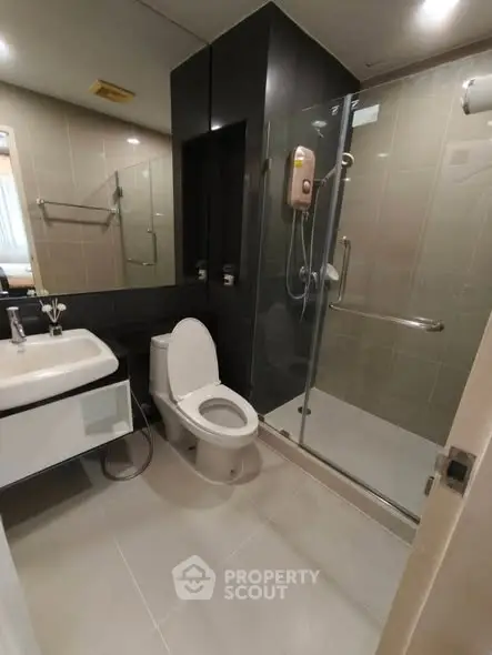Modern bathroom with glass shower and sleek fixtures in a contemporary apartment.