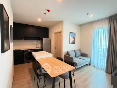 Modern open-layout kitchen and living room with sleek design and natural light.