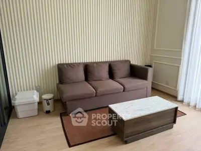 Cozy living room with brown sofa and modern coffee table, featuring elegant striped wallpaper and natural light.