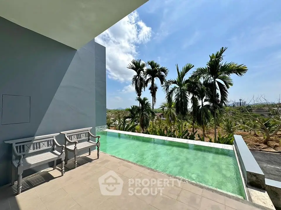 Luxurious rooftop pool with stunning tropical view and elegant seating area.