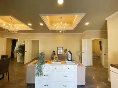 Spacious living room with elegant chandeliers and cozy seating area in a modern home.